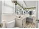 Bright bathroom featuring dual sinks, tile countertop, and decorative mirror at 9015 Mark Twain Ln, Port Richey, FL 34668