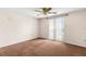 The bedroom has carpet, a ceiling fan, and sliding glass doors at 9015 Mark Twain Ln, Port Richey, FL 34668