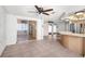 Open-concept living room with tile floors, ceiling fan, and sliding glass doors at 9015 Mark Twain Ln, Port Richey, FL 34668