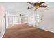 Spacious living room features plush carpet, ceiling fan, and lots of natural light at 9015 Mark Twain Ln, Port Richey, FL 34668
