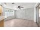 Living room featuring tile flooring, ceiling fan and a brick accent wall at 9015 Mark Twain Ln, Port Richey, FL 34668