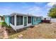View of home exterior, shed, and grass in backyard on a sunny day at 9015 Mark Twain Ln, Port Richey, FL 34668