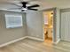 Bedroom featuring a ceiling fan, wood floors, and ensuite bathroom at 9034 Cochise Ln, Port Richey, FL 34668