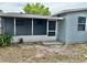 Back exterior view of the home with a screened patio, light blue siding, and a white trim at 9034 Cochise Ln, Port Richey, FL 34668