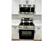 Close-up of new stainless steel oven and microwave, complemented by white cabinetry at 9034 Cochise Ln, Port Richey, FL 34668