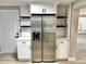 Bright kitchen featuring a stainless steel refrigerator, white cabinets, and black shelving accents at 9034 Cochise Ln, Port Richey, FL 34668