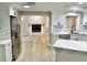 Open-concept kitchen featuring white cabinets, stainless appliances, and hardwood floors at 9034 Cochise Ln, Port Richey, FL 34668