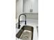 Stainless steel kitchen sink sits beneath a modern black faucet and white marbled countertop at 9034 Cochise Ln, Port Richey, FL 34668