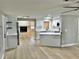 Open-concept kitchen featuring white cabinets, stainless appliances, and hardwood floors at 9034 Cochise Ln, Port Richey, FL 34668