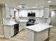 Bright kitchen featuring white cabinets, marble countertops, and stainless steel appliances at 9034 Cochise Ln, Port Richey, FL 34668