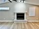 Spacious living room features a decorative fireplace and light hardwood flooring at 9034 Cochise Ln, Port Richey, FL 34668