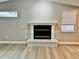 Bright living room features a decorative fireplace and light hardwood flooring at 9034 Cochise Ln, Port Richey, FL 34668