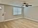 Living room with neutral paint, modern flooring, a ceiling fan, and a window at 9034 Cochise Ln, Port Richey, FL 34668