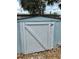 Metal storage shed with a hinged white door in the backyard at 9034 Cochise Ln, Port Richey, FL 34668