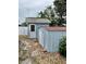 Exterior view of the blue storage shed with a light gray roof in the backyard at 9034 Cochise Ln, Port Richey, FL 34668