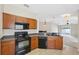 Well-equipped kitchen with dark appliances, ample counter space, and open view to the living area at 9048 Southern Charm Cir, Brooksville, FL 34613