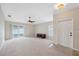 Spacious living room with neutral carpet, ceiling fan, and sliding glass door to the screened in patio at 9048 Southern Charm Cir, Brooksville, FL 34613