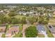 Aerial view showcasing homes with screened pools and lush landscaping in a well-maintained residential community at 9245 Grand Cypress Dr, Spring Hill, FL 34613