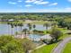 An aerial shot captures a serene pool alongside a lake, surrounded by verdant trees at 9245 Grand Cypress Dr, Spring Hill, FL 34613