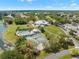 This aerial view shows the lake, golf course, tennis courts, and pool in a neighborhood at 9245 Grand Cypress Dr, Spring Hill, FL 34613