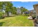 A lush green backyard with trees near a house with a screened lanai at 9245 Grand Cypress Dr, Spring Hill, FL 34613