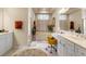 Bright bathroom with double vanity, soaking tub, walk-in shower, tile floors, and natural light at 9245 Grand Cypress Dr, Spring Hill, FL 34613
