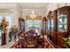 Formal dining room featuring a chandelier, china cabinets, and classic wooden furniture at 9245 Grand Cypress Dr, Spring Hill, FL 34613