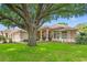 Inviting single-story home with brick driveway, well-manicured lawn, and mature shade trees at 9245 Grand Cypress Dr, Spring Hill, FL 34613