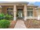 Close-up of front entrance featuring double doors, decorative columns, and manicured landscaping at 9245 Grand Cypress Dr, Spring Hill, FL 34613