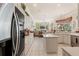 Bright, spacious kitchen boasts white cabinetry, granite countertops, and stainless steel appliances with backyard view at 9245 Grand Cypress Dr, Spring Hill, FL 34613