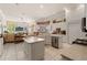 Sun-filled kitchen featuring white cabinets, granite countertops, and an island at 9245 Grand Cypress Dr, Spring Hill, FL 34613