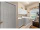 Bright laundry room features a sink, washer, dryer and ample cabinet space at 9245 Grand Cypress Dr, Spring Hill, FL 34613