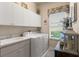 Bright laundry room with white cabinets and modern appliances at 9245 Grand Cypress Dr, Spring Hill, FL 34613