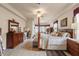 Spacious main bedroom offers a stylish four-poster bed, wood floors, and comfortable sitting area at 9245 Grand Cypress Dr, Spring Hill, FL 34613