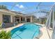 A screened-in pool with furniture on the lanai in this backyard at 9245 Grand Cypress Dr, Spring Hill, FL 34613