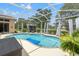 View of a large, screened pool in this sunny backyard at 9245 Grand Cypress Dr, Spring Hill, FL 34613