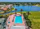 Aerial view of a large pool with sun loungers, adjacent to the golf course and lake at 10187 Holly Berry Dr, Weeki Wachee, FL 34613