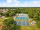 Aerial view showcasing community pickleball and tennis courts amid lush greenery, offering residents recreational options at 10187 Holly Berry Dr, Weeki Wachee, FL 34613