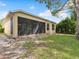 Exterior rear view of the property showcasing the screened-in patio and spacious yard at 10187 Holly Berry Dr, Weeki Wachee, FL 34613