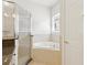 A bathroom with tiled floors, a soaking tub, and a separate glass-enclosed shower at 10187 Holly Berry Dr, Weeki Wachee, FL 34613