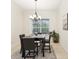 Dining room boasts a modern chandelier, window, and seating for four at 10187 Holly Berry Dr, Weeki Wachee, FL 34613