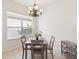 A well lit dining room with a gray wooden table and an ornate chandelier at 10187 Holly Berry Dr, Weeki Wachee, FL 34613