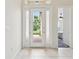 Bright entryway with tile flooring, white trim, and a clear view of the brick walkway outside at 10187 Holly Berry Dr, Weeki Wachee, FL 34613