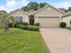 Welcoming home with a well-maintained lawn and a brick-paved driveway at 10187 Holly Berry Dr, Weeki Wachee, FL 34613