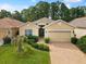 Charming single-story home featuring a two-car garage, brick driveway, and a well-manicured front yard at 10187 Holly Berry Dr, Weeki Wachee, FL 34613