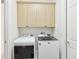 A laundry room featuring a washer and dryer set with cabinets above for storage at 10187 Holly Berry Dr, Weeki Wachee, FL 34613