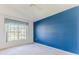Bright bedroom features neutral carpet, blue accent wall, large window, and white trim at 1032 Walnut Hill Ct, Spring Hill, FL 34609