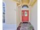 Close-up of the vibrant red front door with decorative glass and a tiled entryway at 1032 Walnut Hill Ct, Spring Hill, FL 34609