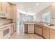 The kitchen features white appliances, light wood cabinets, tile backsplash, and plenty of natural light at 1032 Walnut Hill Ct, Spring Hill, FL 34609