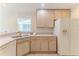 Kitchen features light wood cabinets, matching white appliances, and charming floral wallpaper at 1032 Walnut Hill Ct, Spring Hill, FL 34609